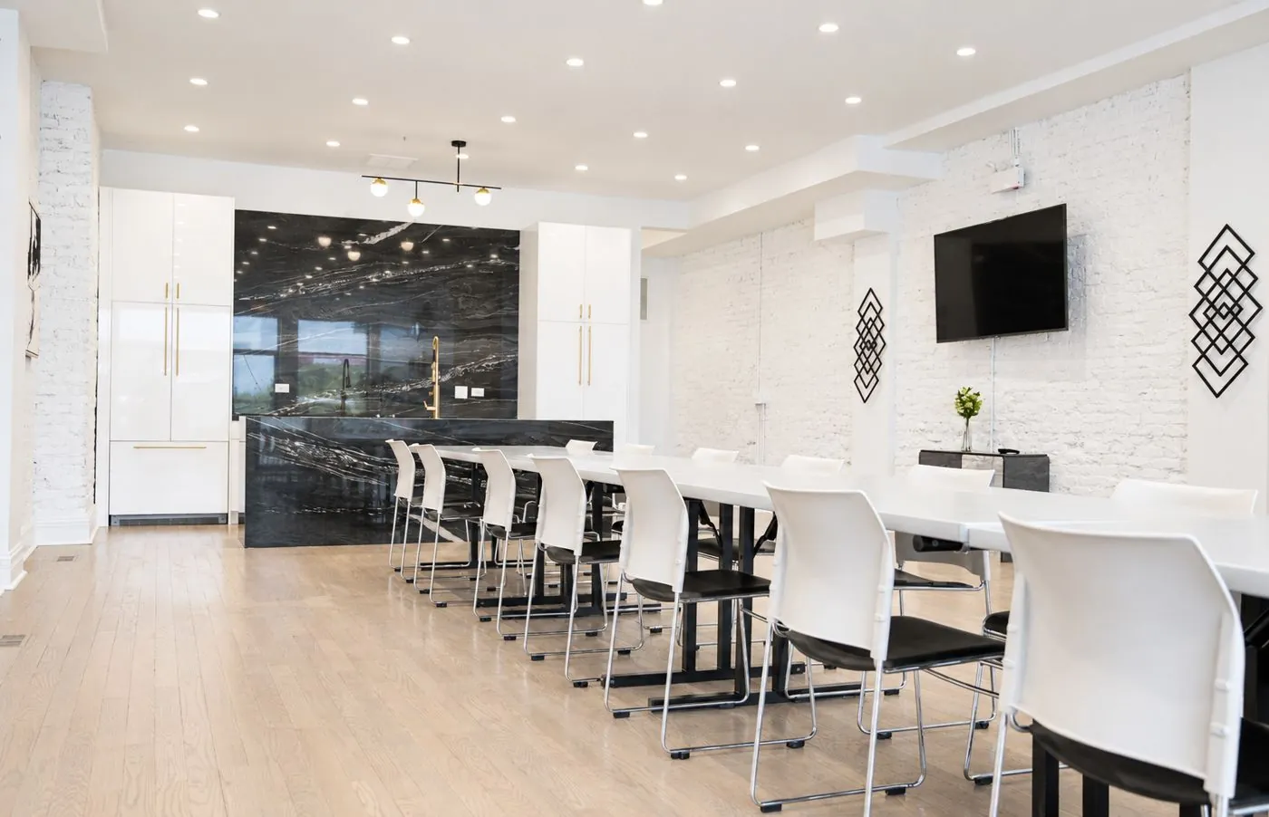 Long banquet table setup leading to the black marble kitchen island at 3535 Venue