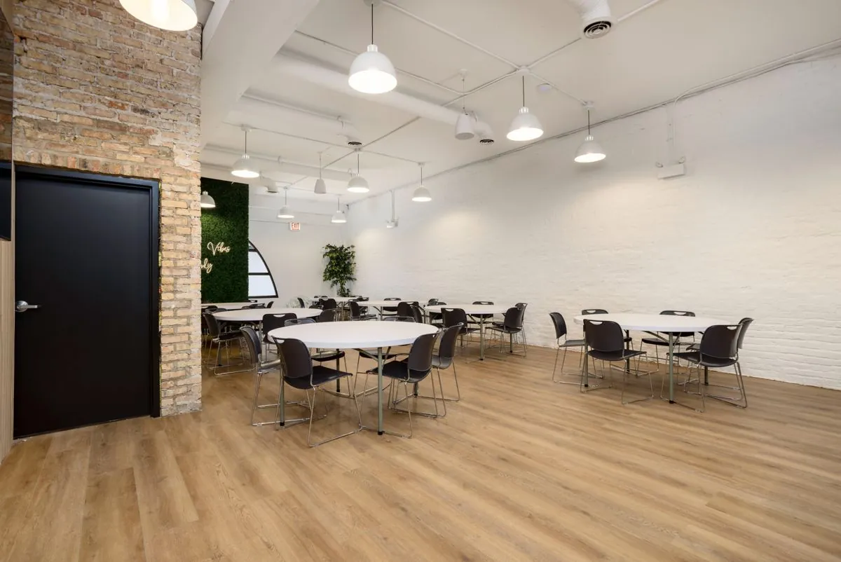 Montrose Studio round tables and stacking chairs toward the arched window