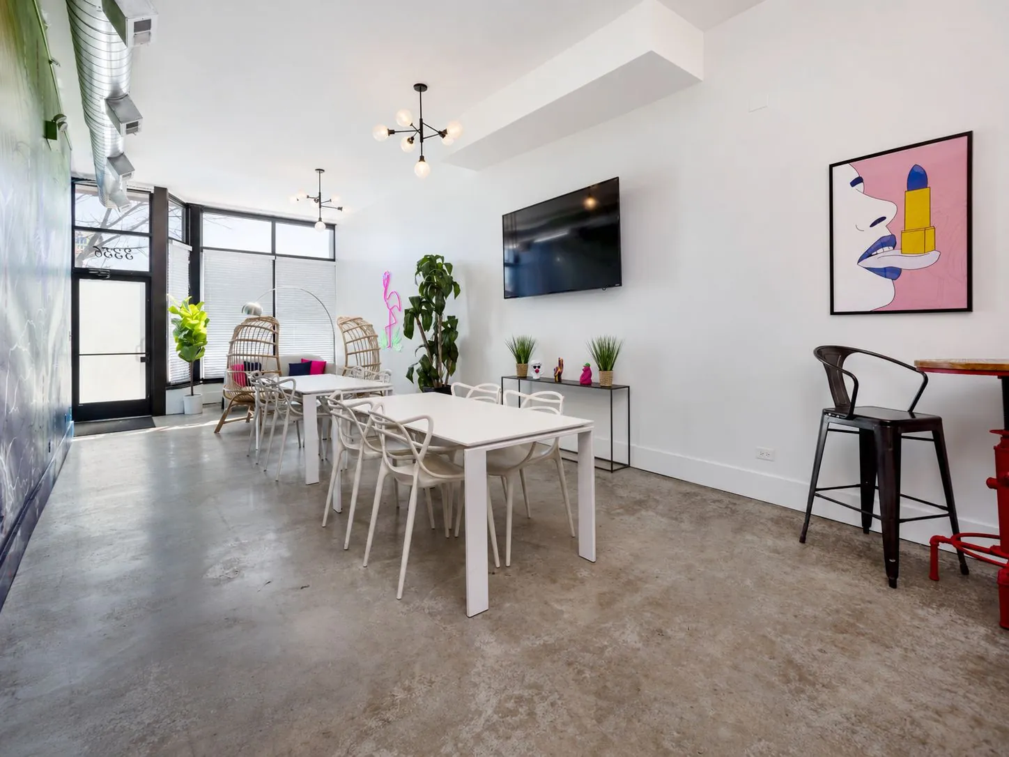 View from the bar corner toward the entrance, with dining tables and pop-art prints